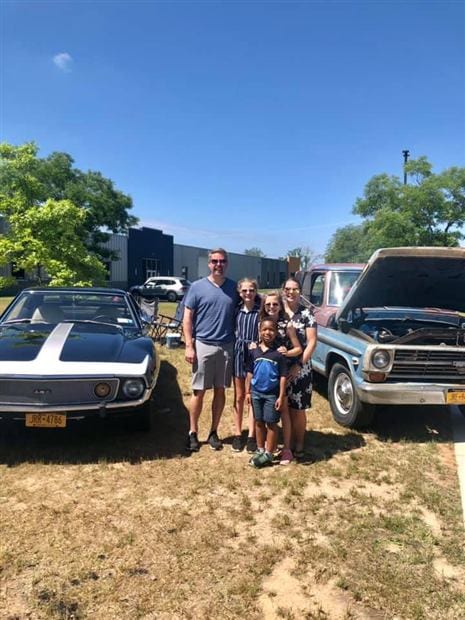 The Wilson family together beside the Javelin and another classic vehicle