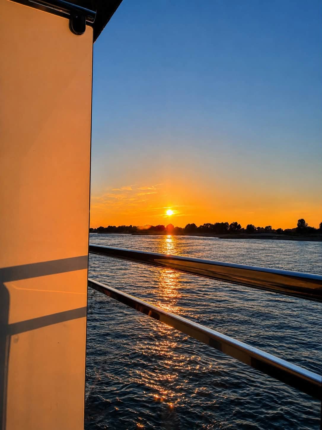 Sunset reflected on the river and the ship