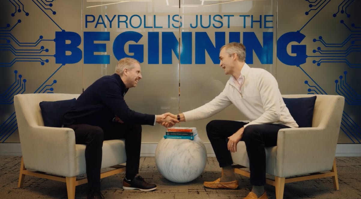 Dave Wilson and Greg Callahan shaking hands on set for Bain's Winning with AI interview