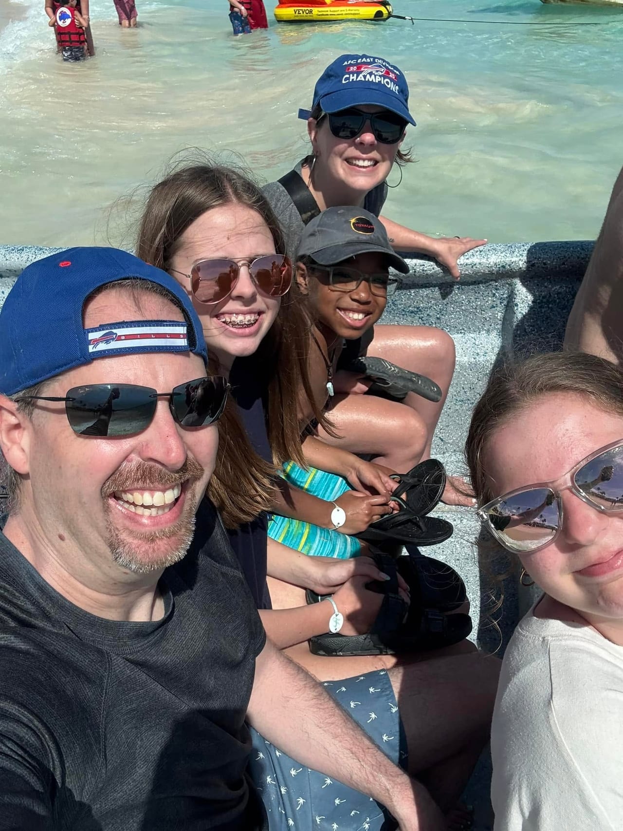 The family smiling together on a boat