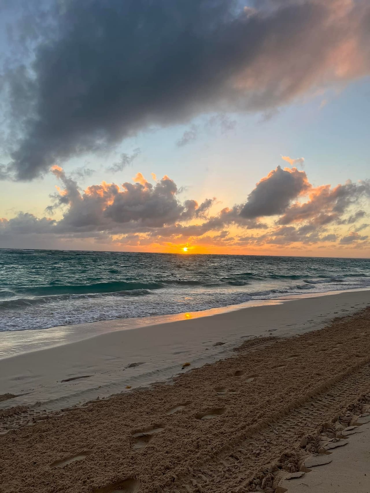 The sun setting over the ocean and the beach