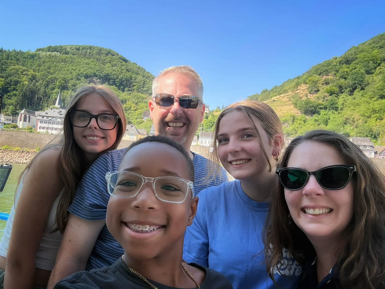 All five of us in a selfie on deck, with the hills of the Rhine Gorge behind