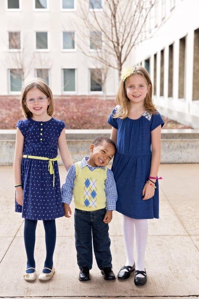 Bella and Abbi in matching blue dresses with Aidan between them outside the courthouse